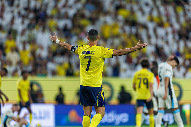 Cristiano Ronaldo celebrates during a match for Al Nassr in the Saudi Pro League wearing a yellow jersey with number 7.