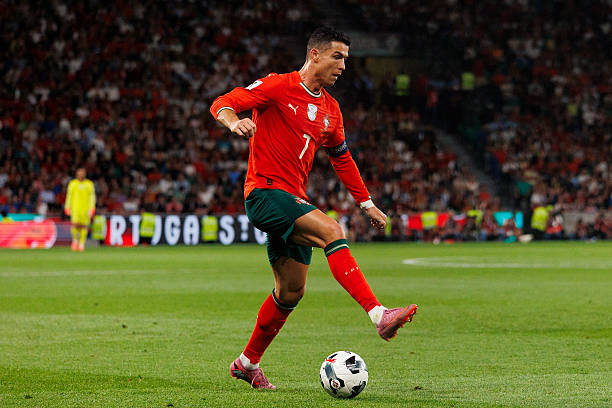 Cristiano Ronaldo controlling the ball during an international match for Portugal national football team in red kit.